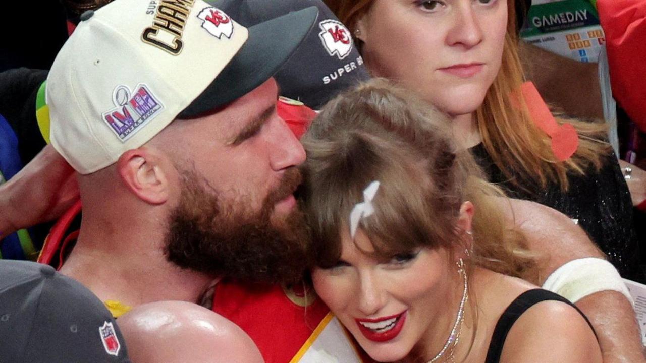Travis Kelce and Taylor Swift hugging in a crowd