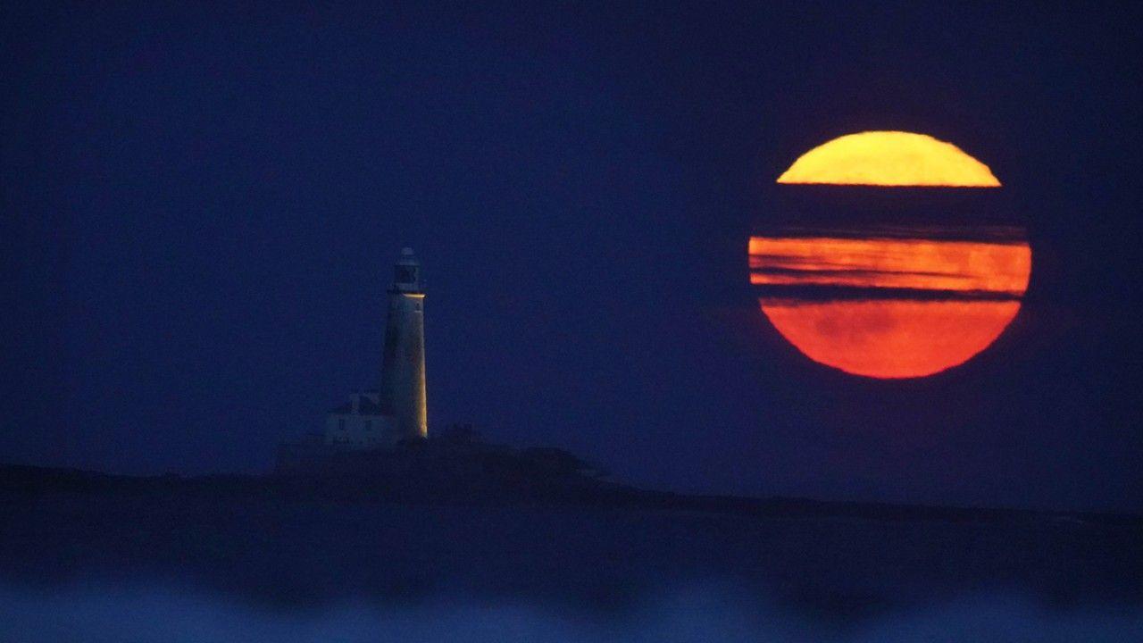 The Full Buck supermoon rises over St Mary's Lighthouse in Whitley Bay on the north east coast of England in July 2023