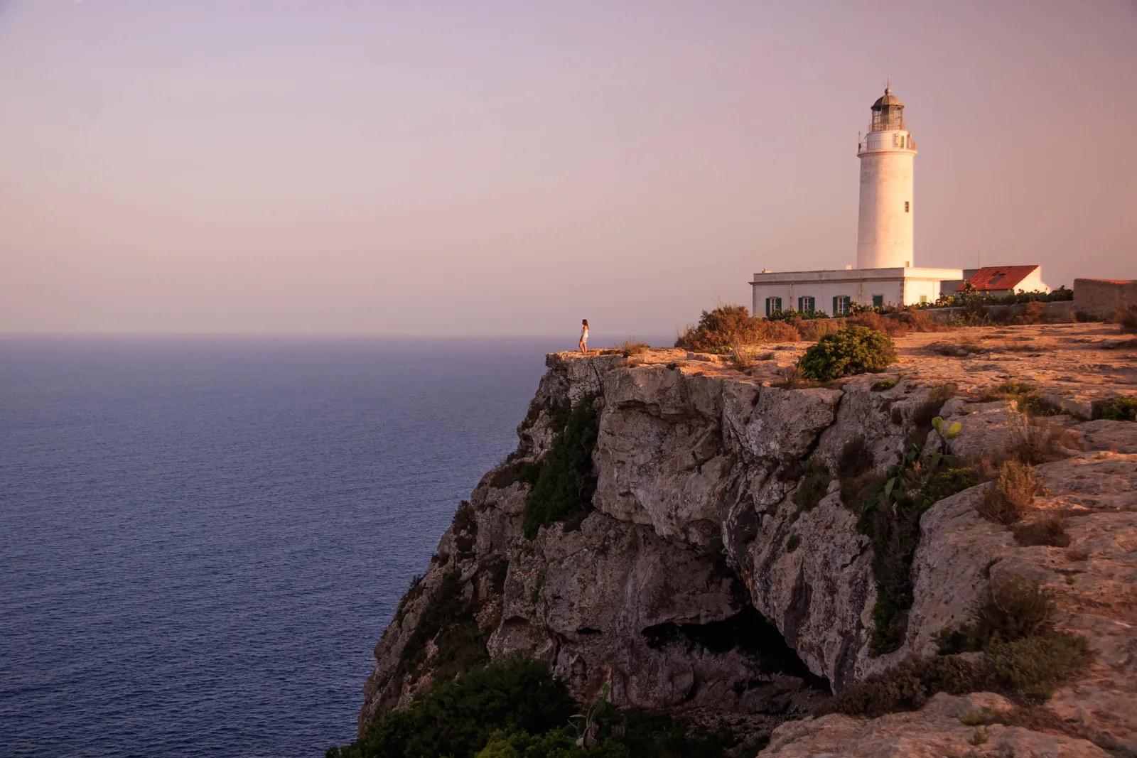 Image may contain Cliff Nature Outdoors Rock Sky Horizon Scenery Architecture Building Sea Water and Person