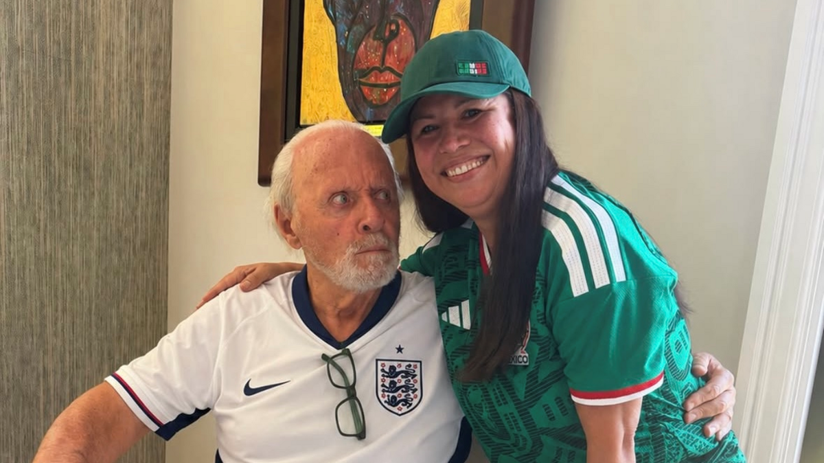 Anthony Hopkins and his wife pose with an England football shirt and a Mexico football shirt