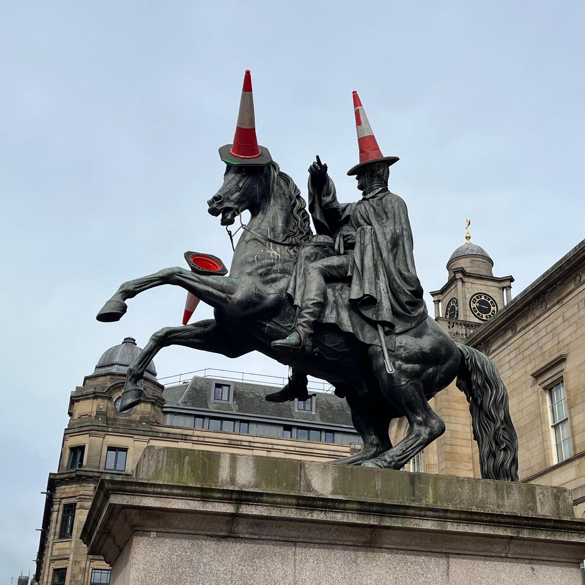 The Duke of Wellington statue in Edinburgh with traffic cones on it.