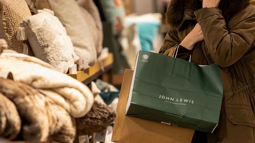 Woman with a John Lewis shopping bag in the department store