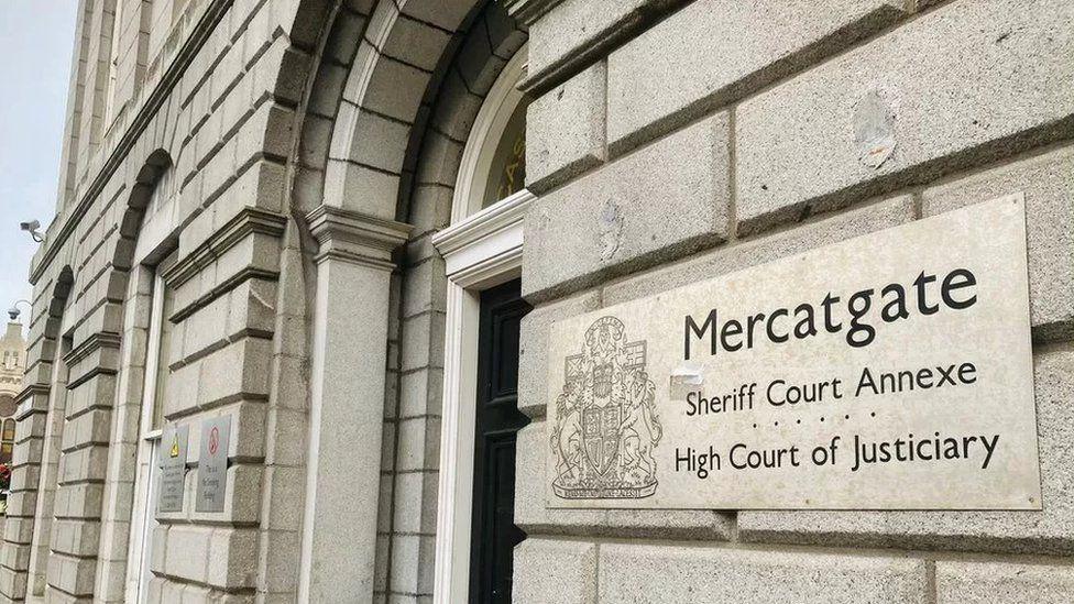 The exterior of the High Court in Aberdeen. A sign on a pale grey building reads Mercatgate / Sheriff Court Annexe / High Court of Justiciary