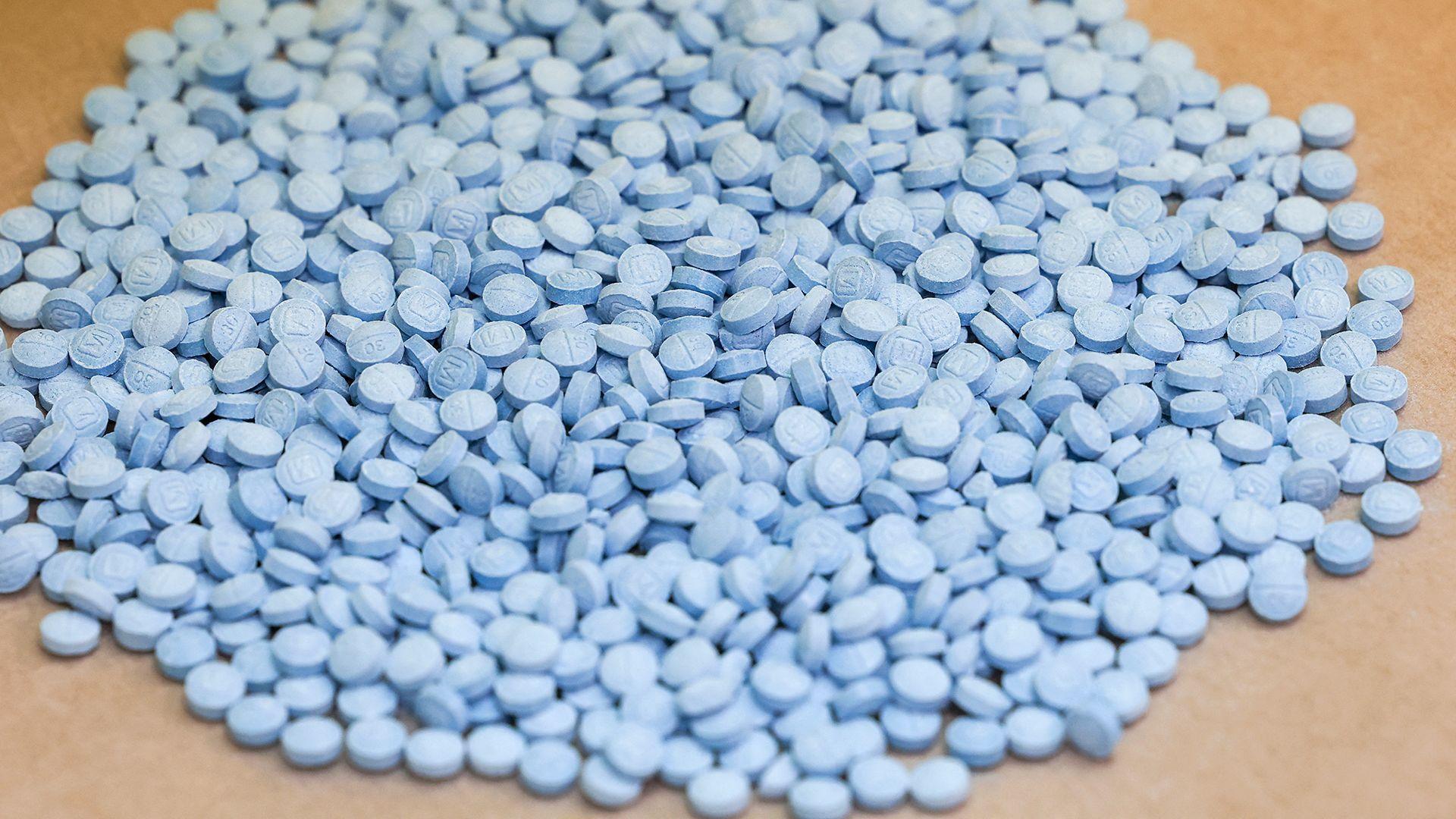 A large pile of small blue pills.