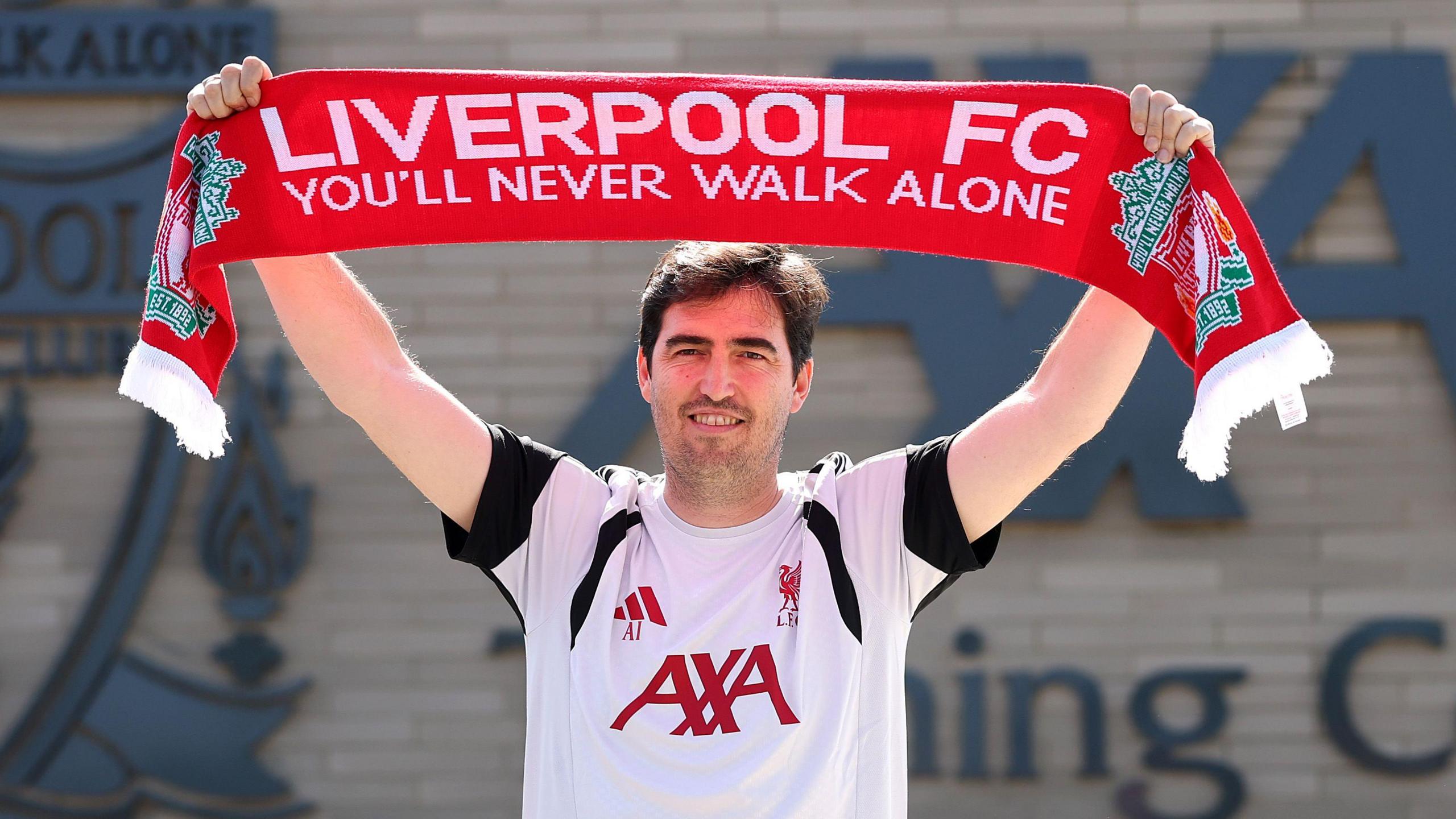 Andoni Iraola holds a liverpool scarf above his head