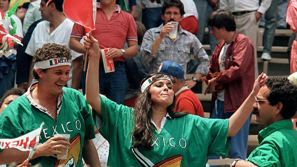 A man and woman supporting Mexico smile and dance during a match at the 1986 World Cup at Estadio Azteca in Mexico City
