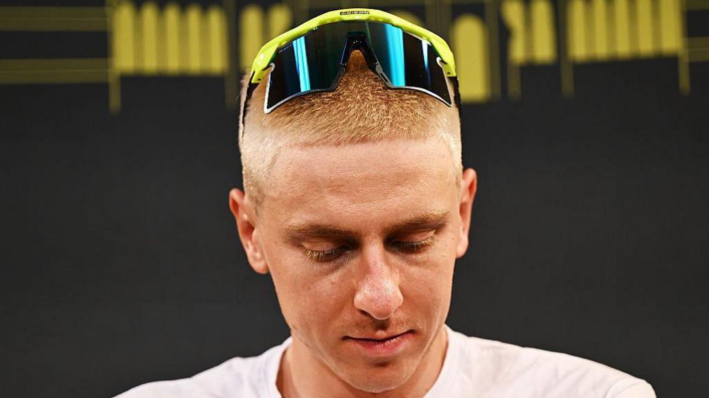 Tadej Pogacar looks downwards as he sports a close-cropped blond hairstyle