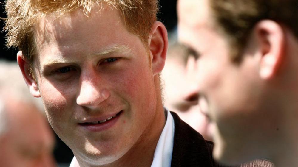 A young Prince Harry in a white shirt and black blazer