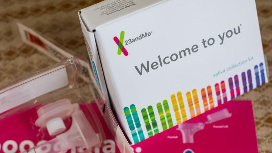 23andMe DNA testing kit, showing the box which has lots of colourful stripes on it, and some plastic tubes.
