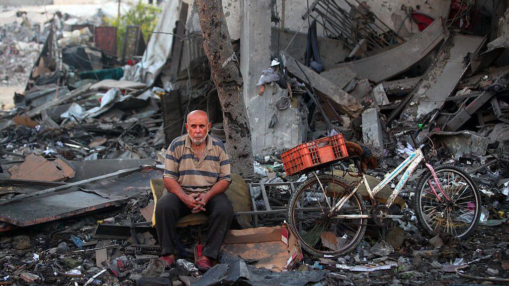 A Palestinian man rests amid debris at the site of an Israeli strike on a house in Gaza City, on July 30, 2026.