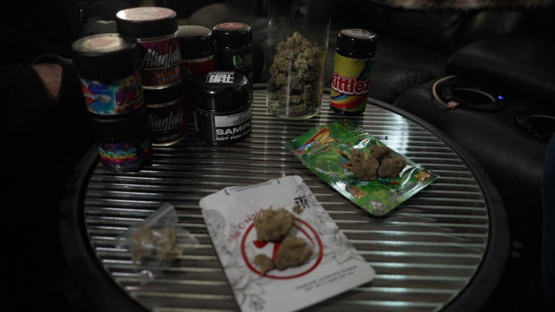 Tables showing plastic packets and jars bearing the names of "Cali" cannabis strains with skunk-style weed that was in them.