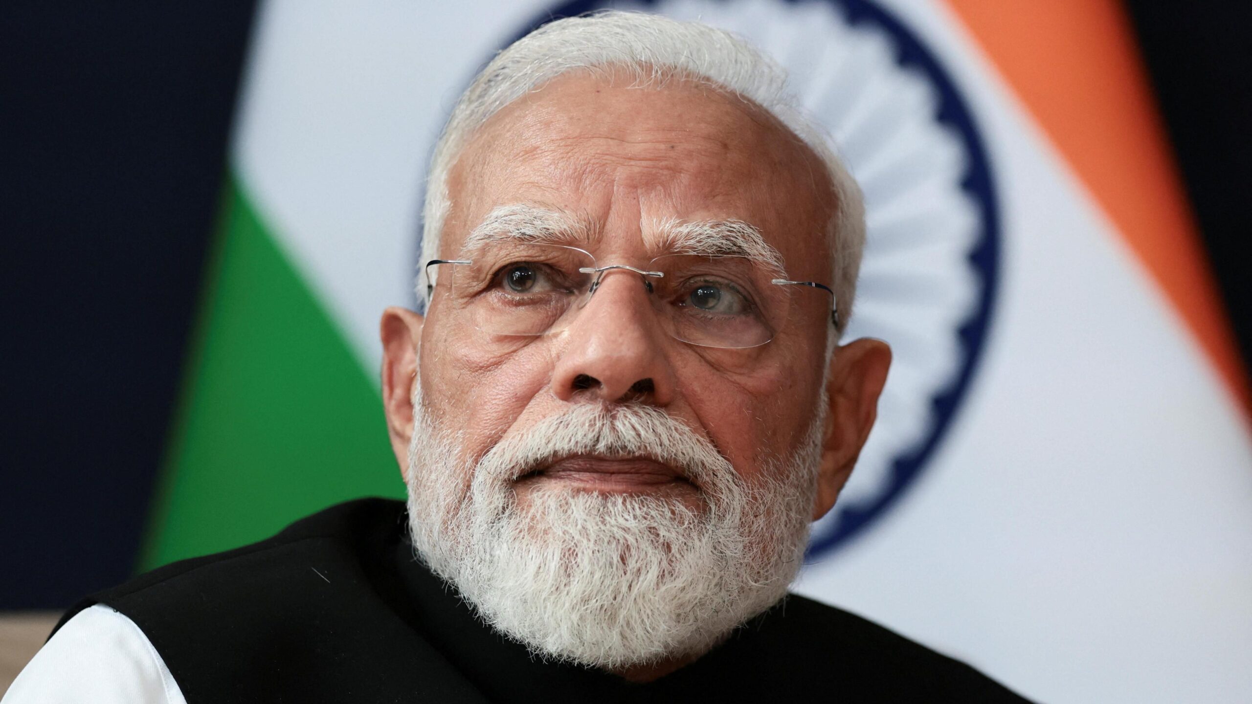 India Prime Minister Narendra Modi sitting in front of an India flag