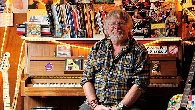 Bill Oddie photographed at home in front of a piano