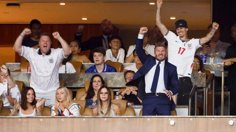 David Beckham celebrates an England goal from his family box in Miami while Victoria stays calmly seated