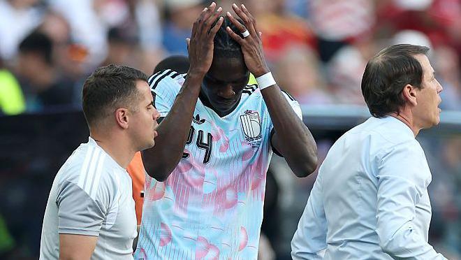 Belgium midfielder Amadou Onana holds his head after suffering a knee injury against the US