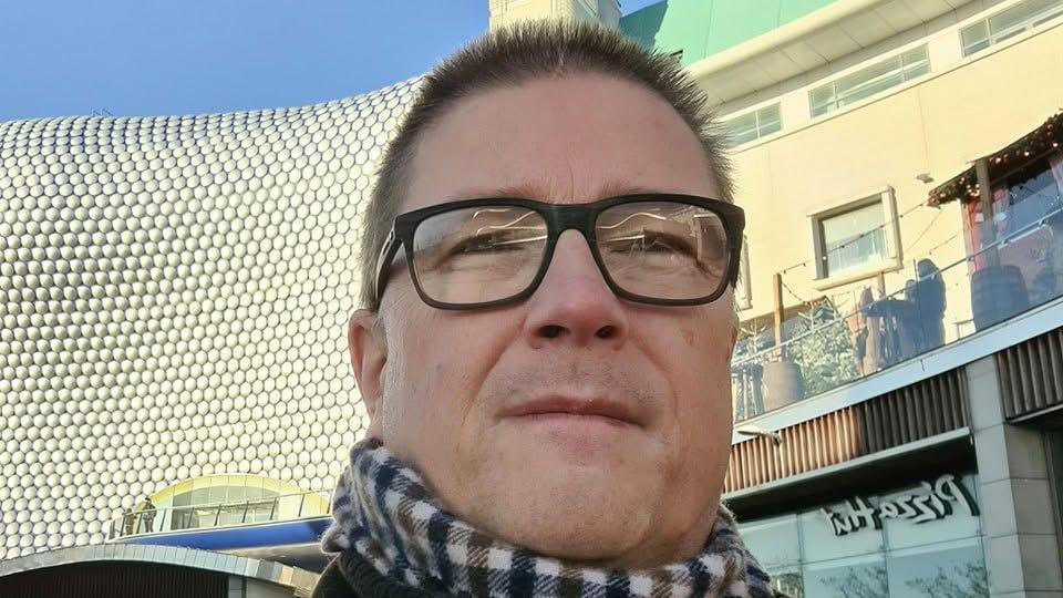 A picture of Graham Parsons. He is standing in front of the Bullring in Birmingham