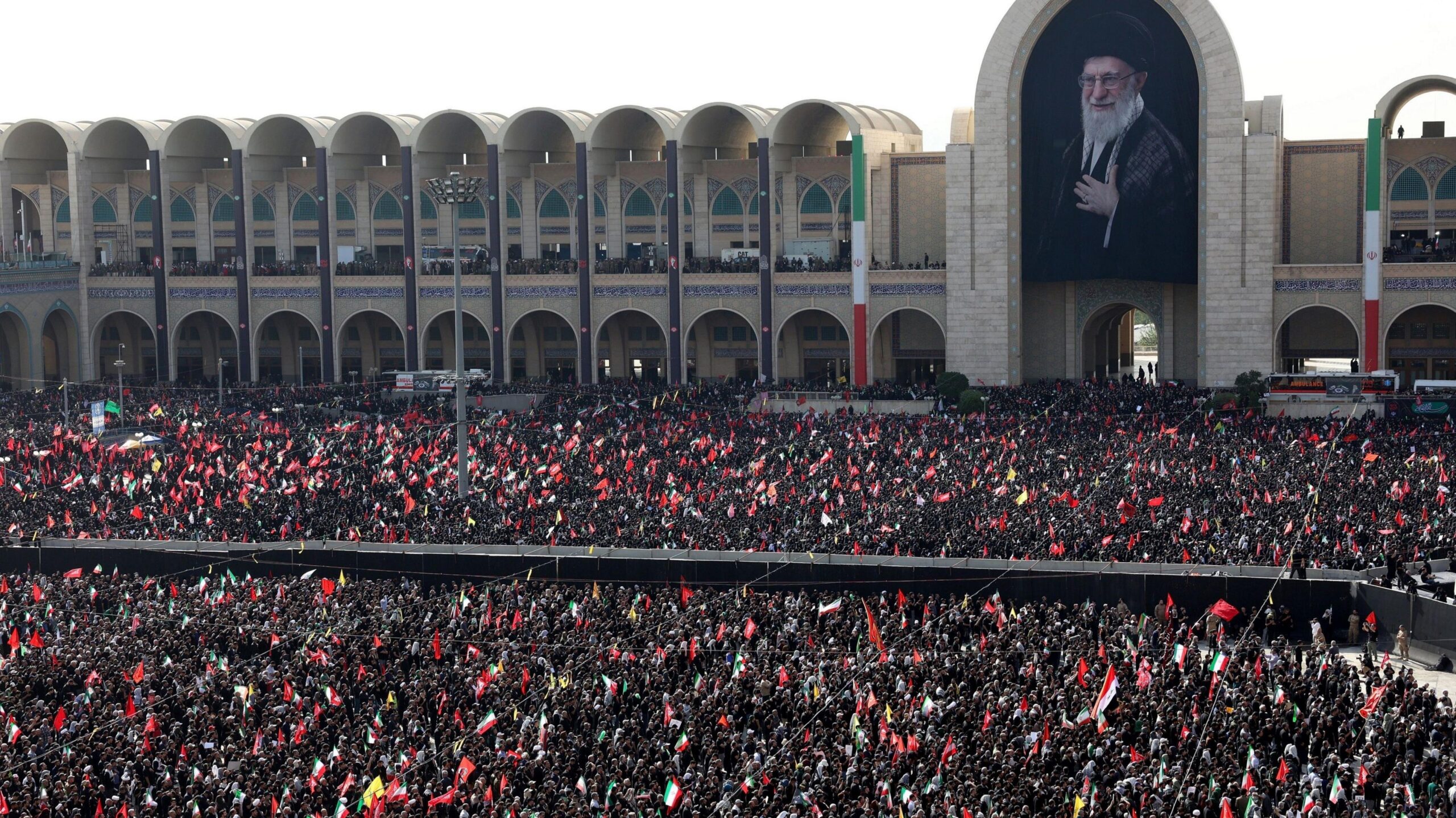 Thousands of Iranians gather in the courtyard of the Grand Mosalla below a large portrait of the late Ayatollah Khamenei