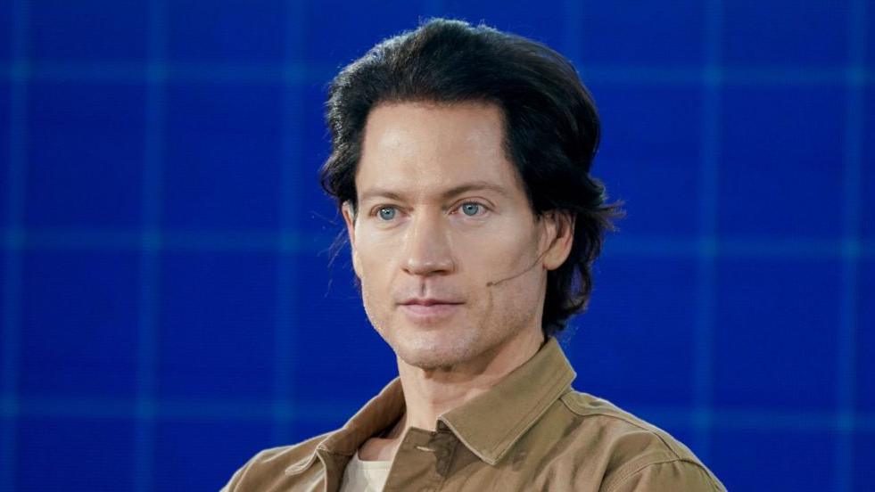 Bryan Johnson pictured in 2021 - he has swept-back dark hair, blue eyes and is wearing a pale brown shacket.