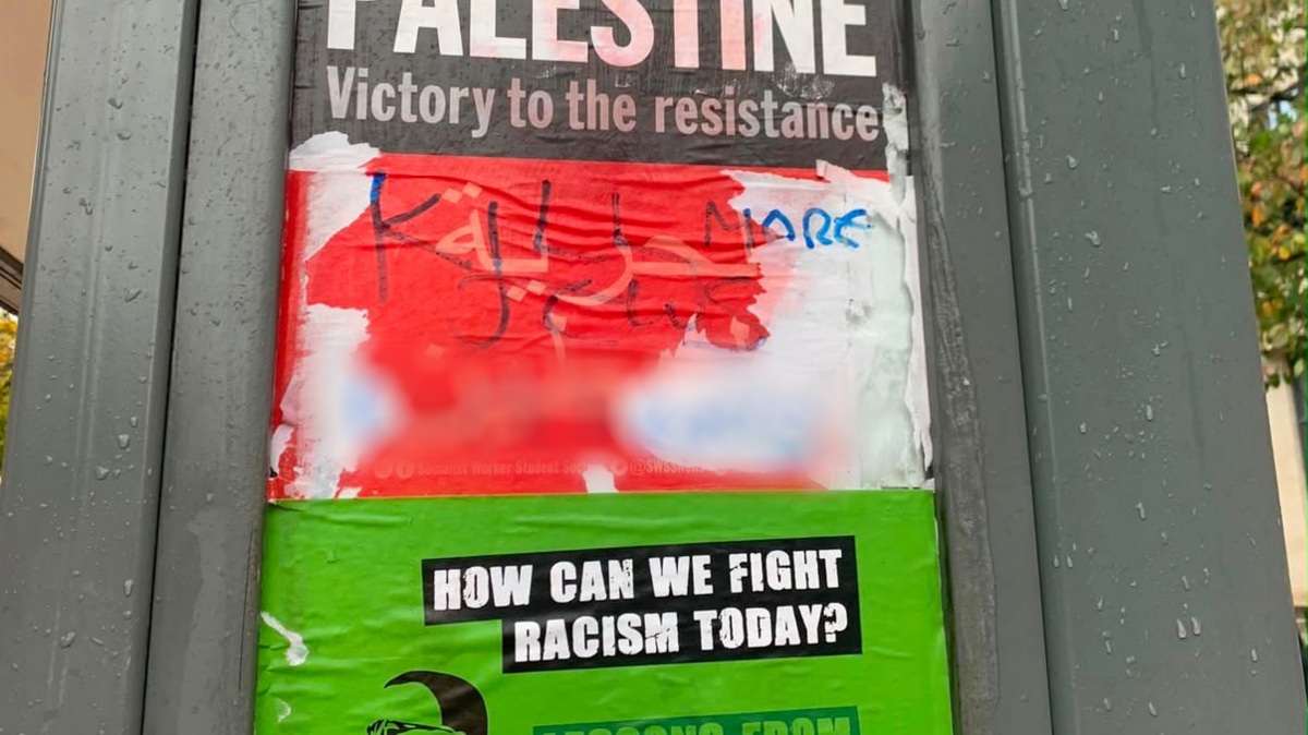 Graffiti reading ‘Kill More Jews’ written over a pro-Palestine and anti-racism poster on the side of a bus stop shelter.