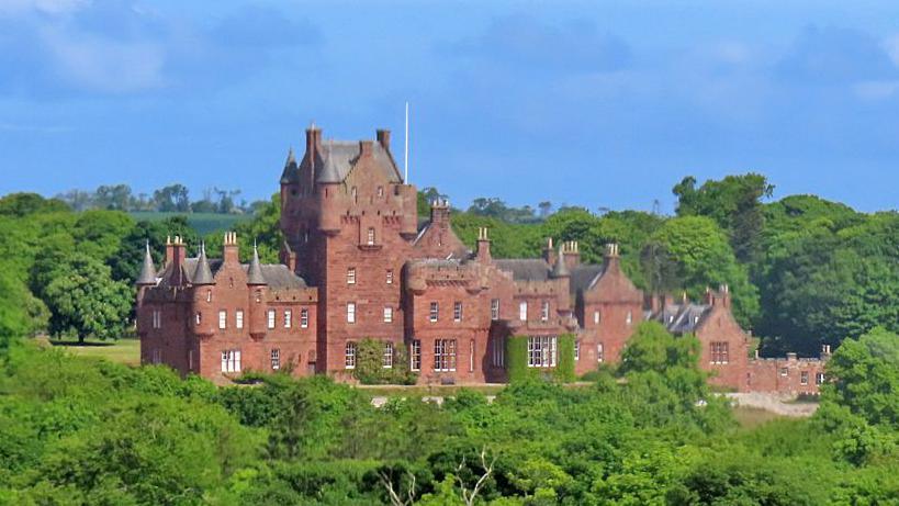 Ayton Castle - an imposing sandstone building with various turrets surrounded by trees