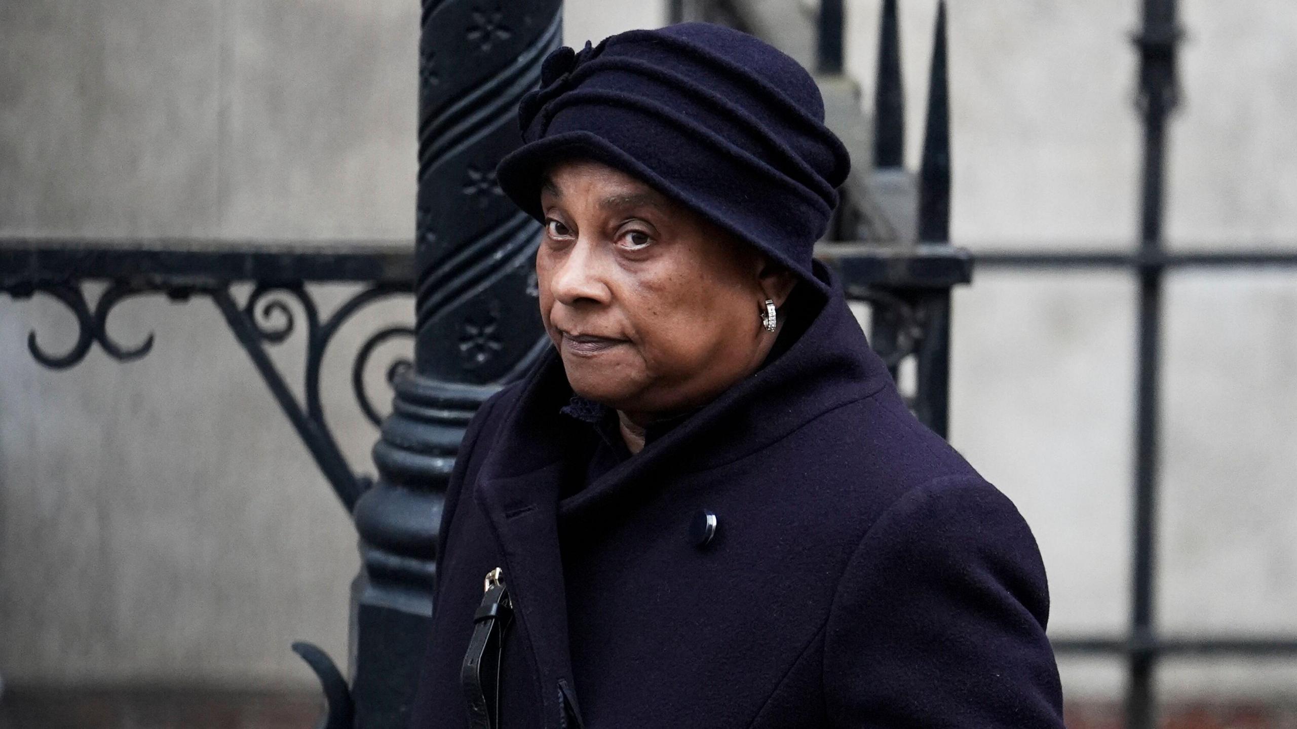 Mid-shot of Baroness Doreen Lawrence wearing a black coat and black hat looking off-camera.