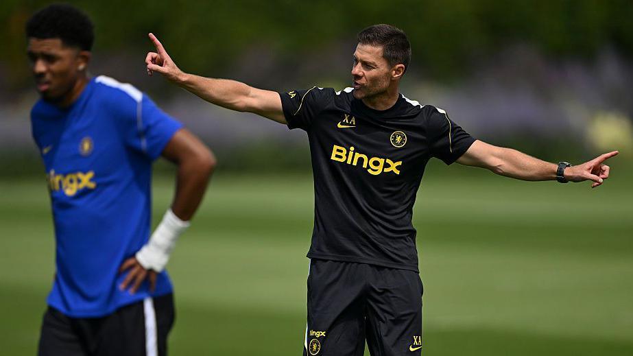 Xabi Alonso pointing with both fingers outstretched in training and Chelsea defender Wesley Fofana is in the foreground