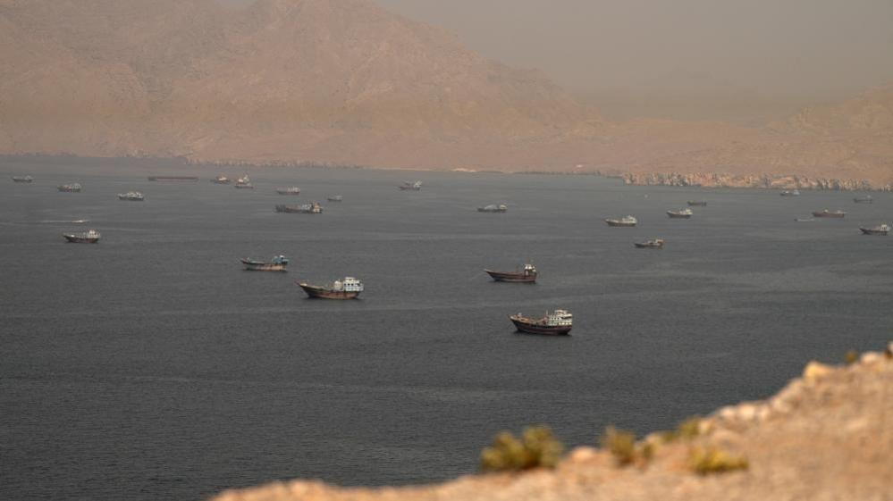Dozens of vessels are seen in the Strait of Hormuz, surrounded by rocky mountains, from Musandam, Oman