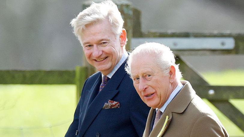 King Charles and Sir Clive Alderton walk together outside