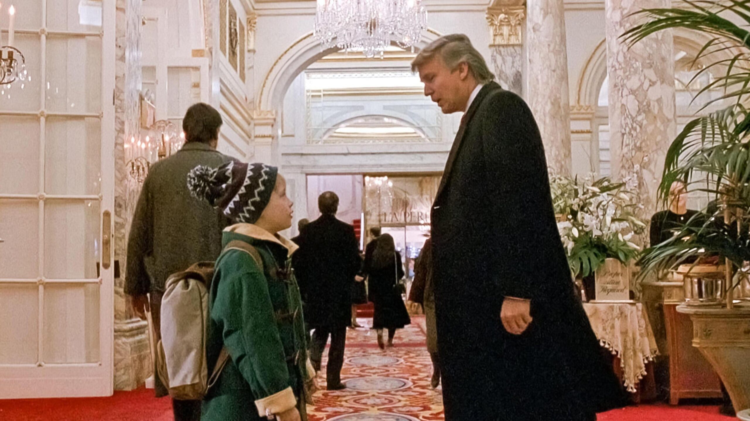 Screenshot from Home Alone 2, where Kevin, played by Macaulay Culkin,  bumps into Donald Trump in the lobby of the Plaza Hotel
