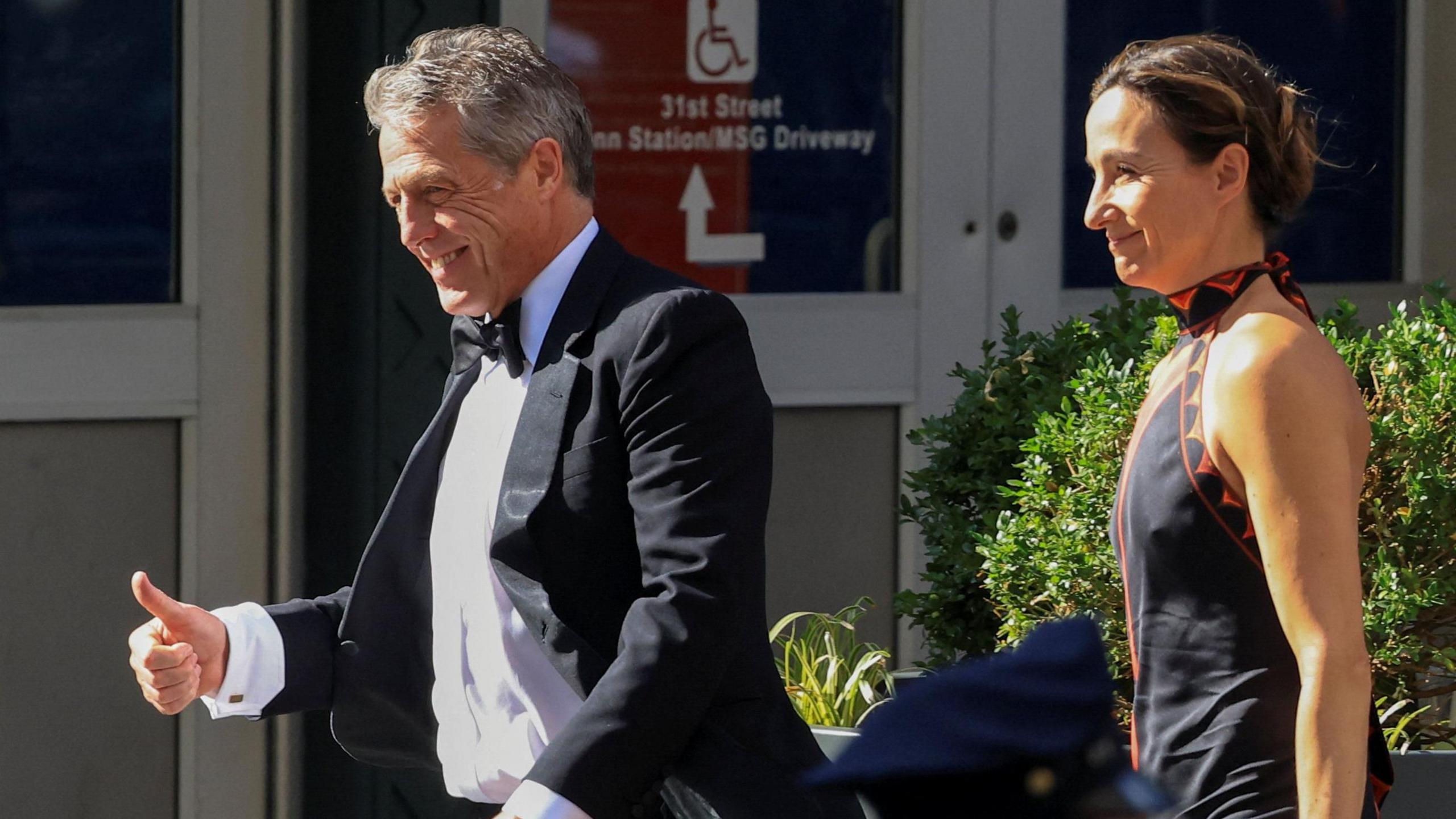 US actor Hugh Grant and his wife Anna Elisabet Eberstein wear formalwear as they walk up to the entrance of Madison Square Garden.