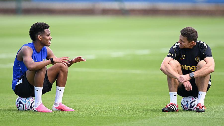 Xabi Alonso talking to Estevao Willian while both are sat on balls