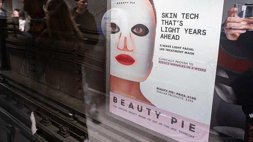 Photo of a poster advert at a London Underground station. The poster features a woman with a large white mask on her face. The text reads:  Skin tech that's light years ahead C-wave light facial treatment mask Clinically proven to reduce wrinkles in four weeks Beauty Pie+ price: £120 Similar products: £299 Beauty Pie: the insider beauty brand for out-of-the-box thinker