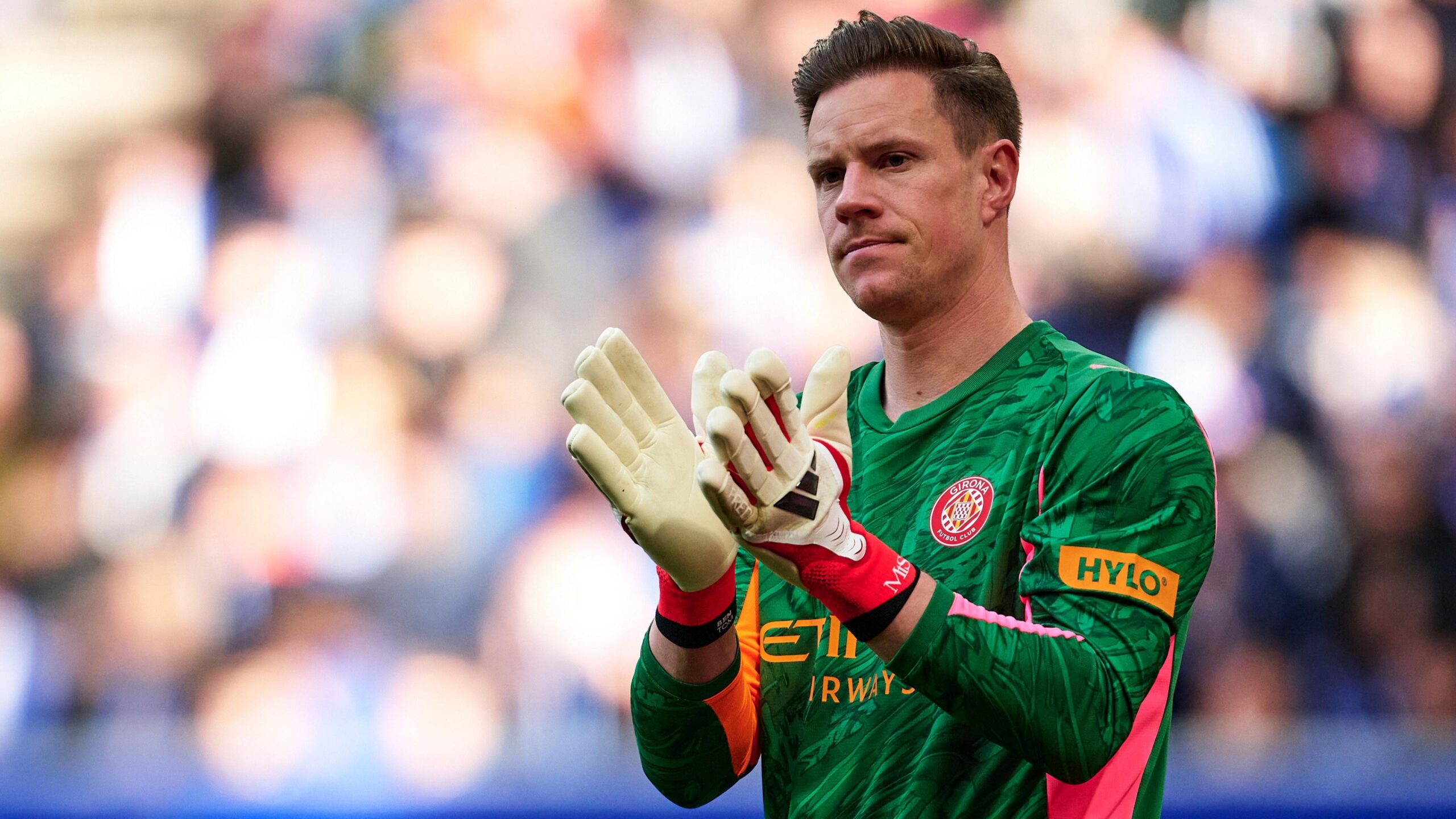 Marc Andre ter Stegen in a green Girona goalkeeper's jersey applauds fans