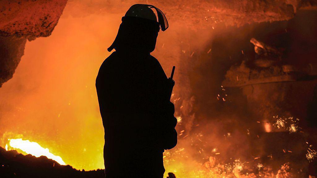 A silhouette of a steel worker