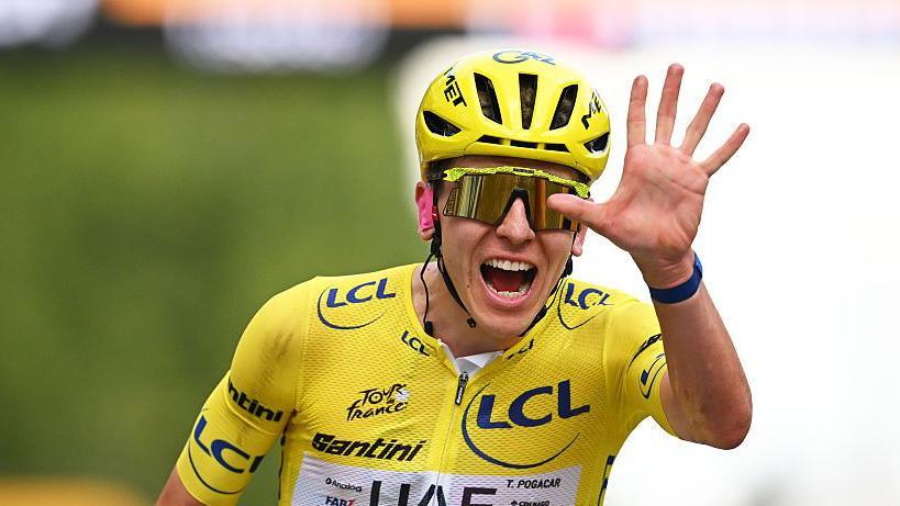 Tadej Pogacar celebrates winning a fifth Tour de France by showing five fingers