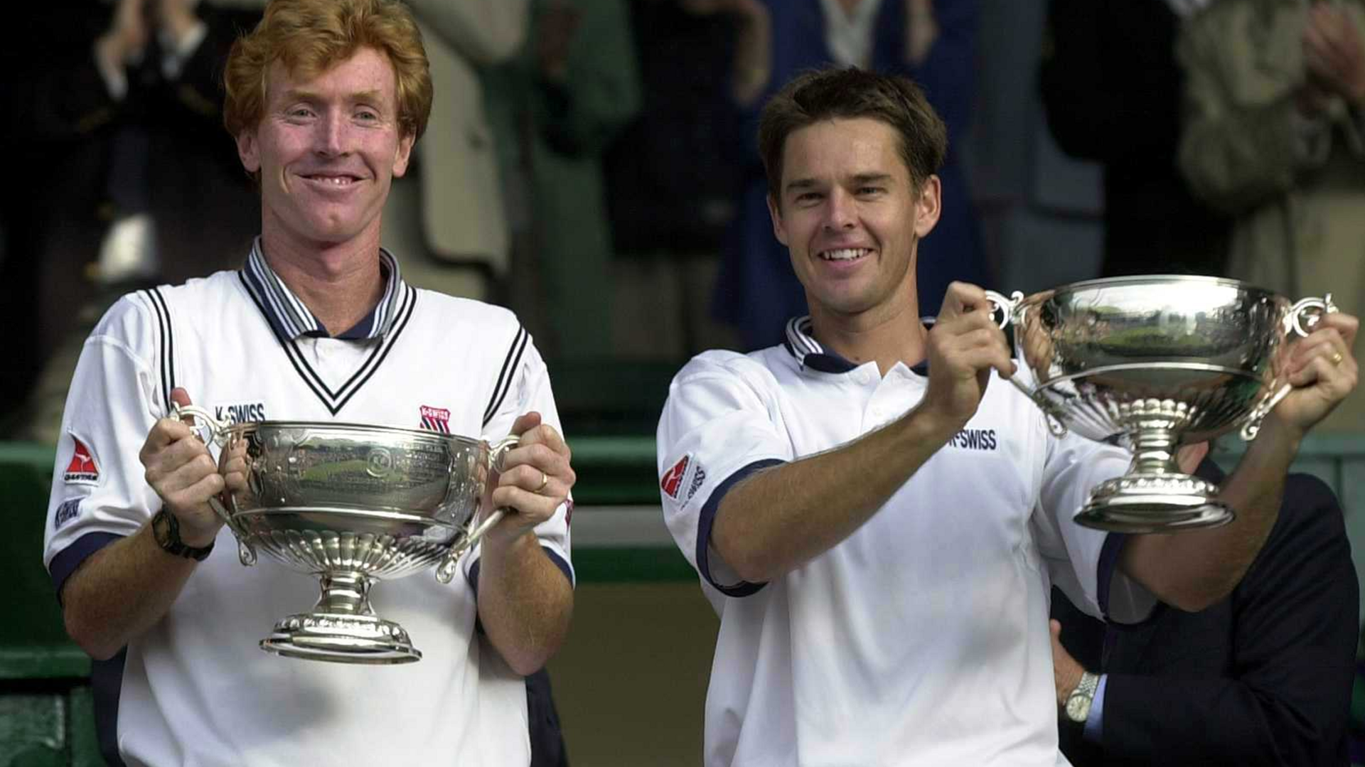 Mark Woodforde and Todd Woodbridge of Australia holding men's doubles trophies in 2000