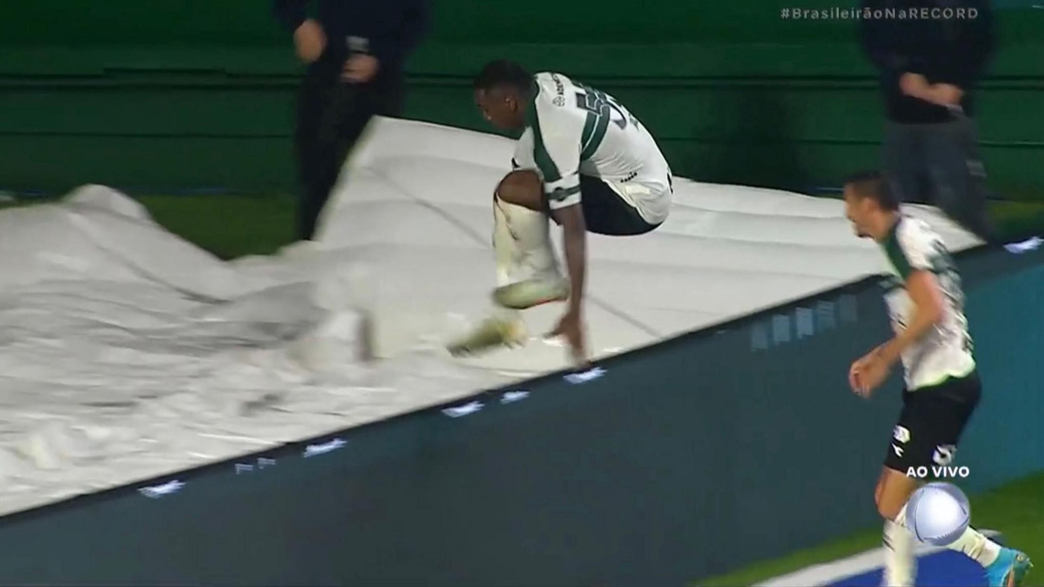 Image of Jacy Maranhao falling down a hole after jumping over the advertising boards