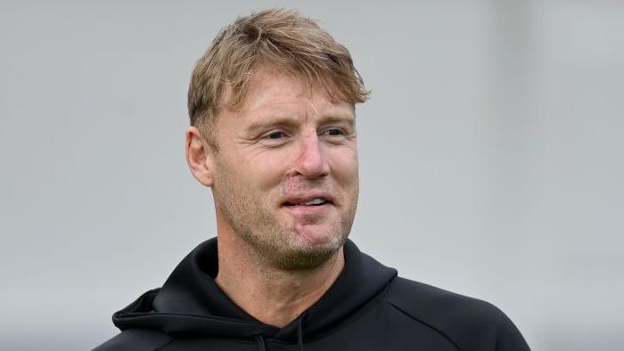 Andrew Flintoff with a neutral expression, wearing a black hoodie