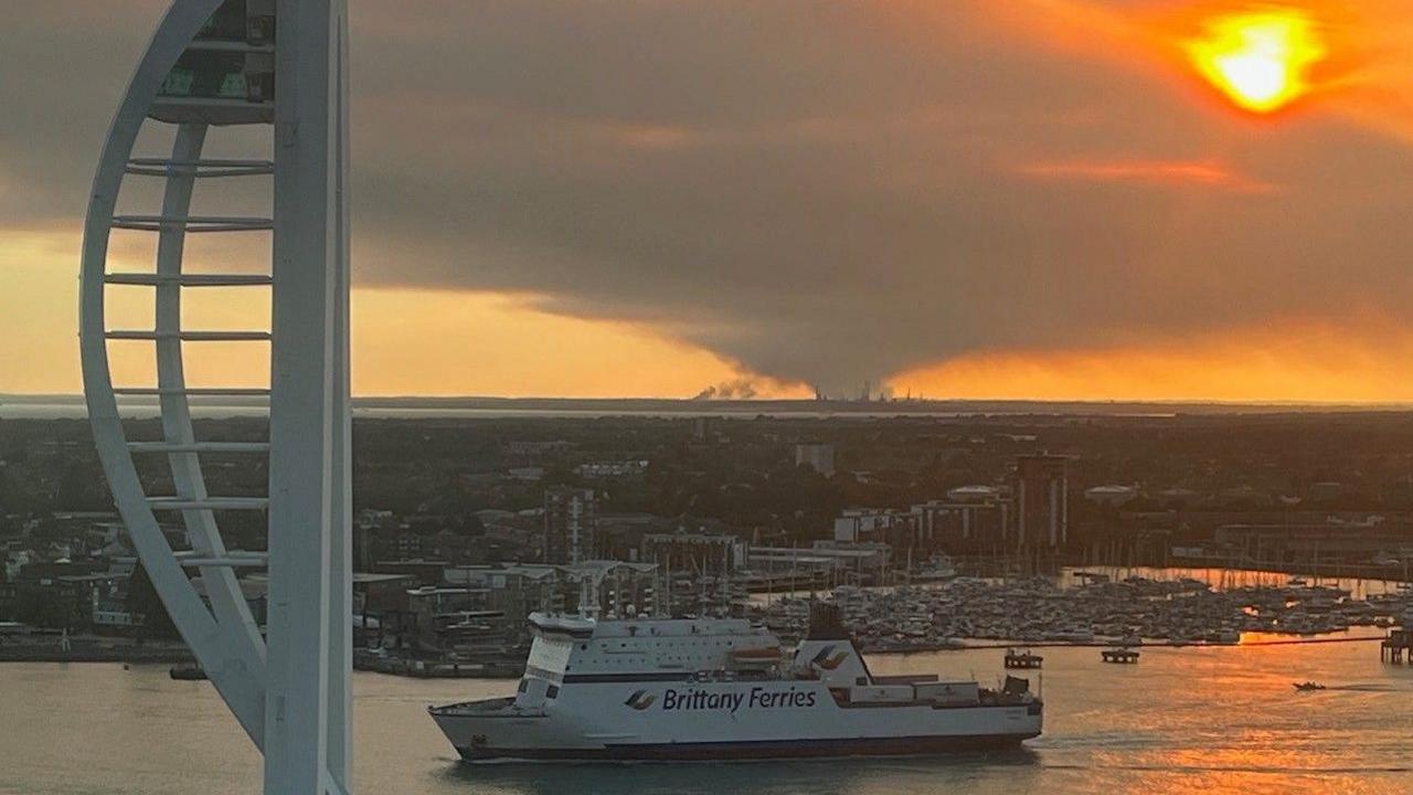 New Forest fire seen from Portsmouth with the Spinnaker Tower and ferry in the foreground.