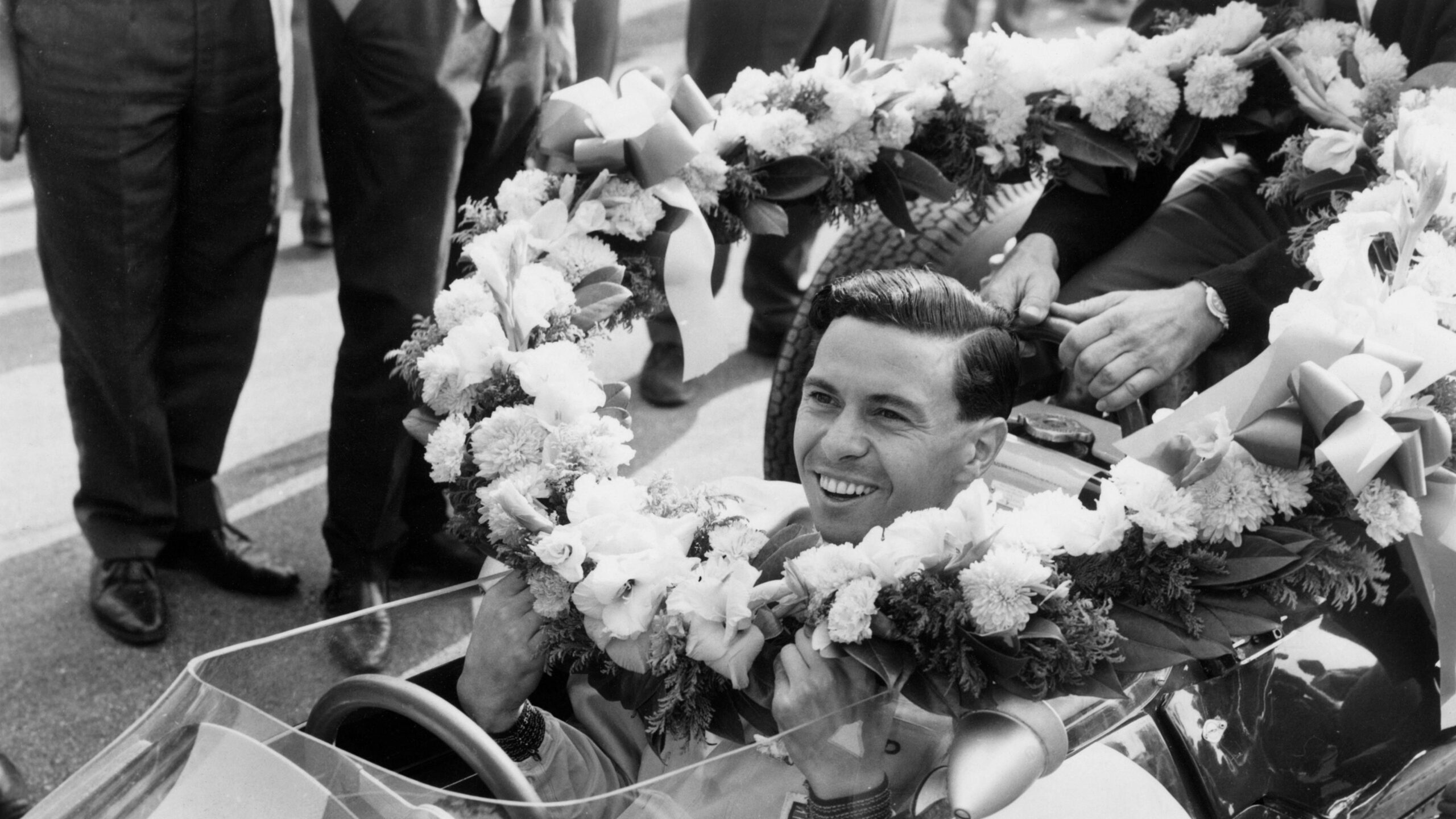 A laurel wreath is placed around the neck of Lotus' Jim Clark after he won the 1963 Italian Grand Prix to secure his first drivers' championship