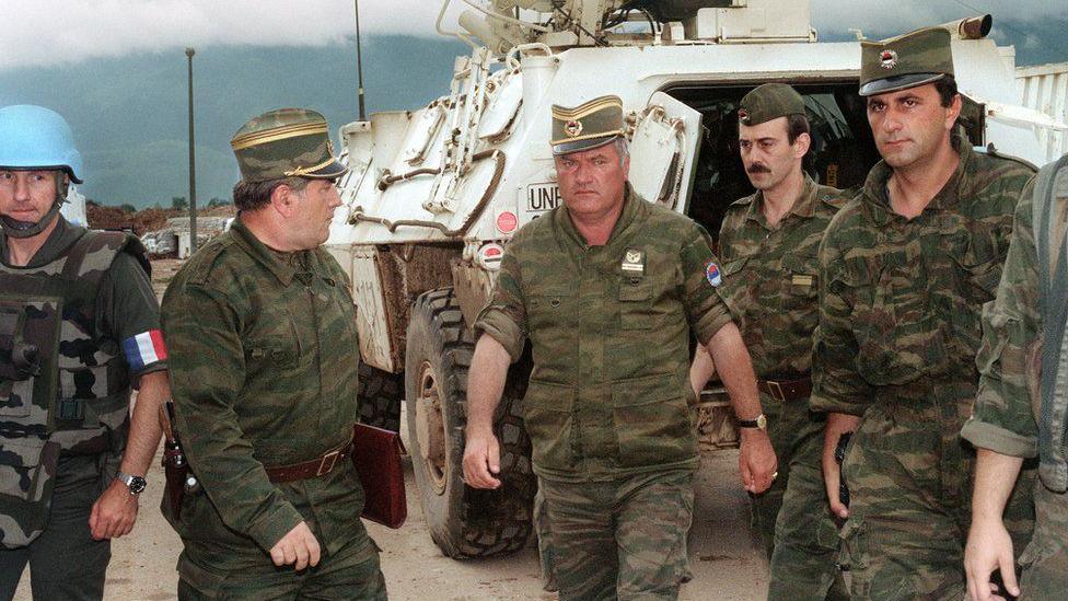 Ratko Mladic is photographed in military uniform surrounded by his fellow officers during the war in the Balkans