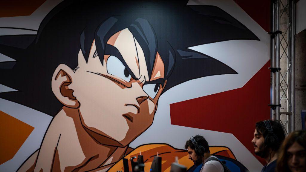 A graphic from the Dragon Ball Z comic is seen displayed on a wall above several people on computers