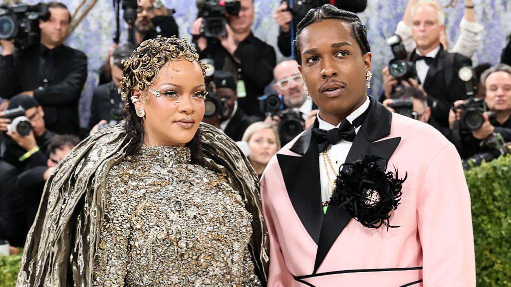 Rihanna and ASAP Rocky on the red carpet of the Met Gala. There are many photographers behind them