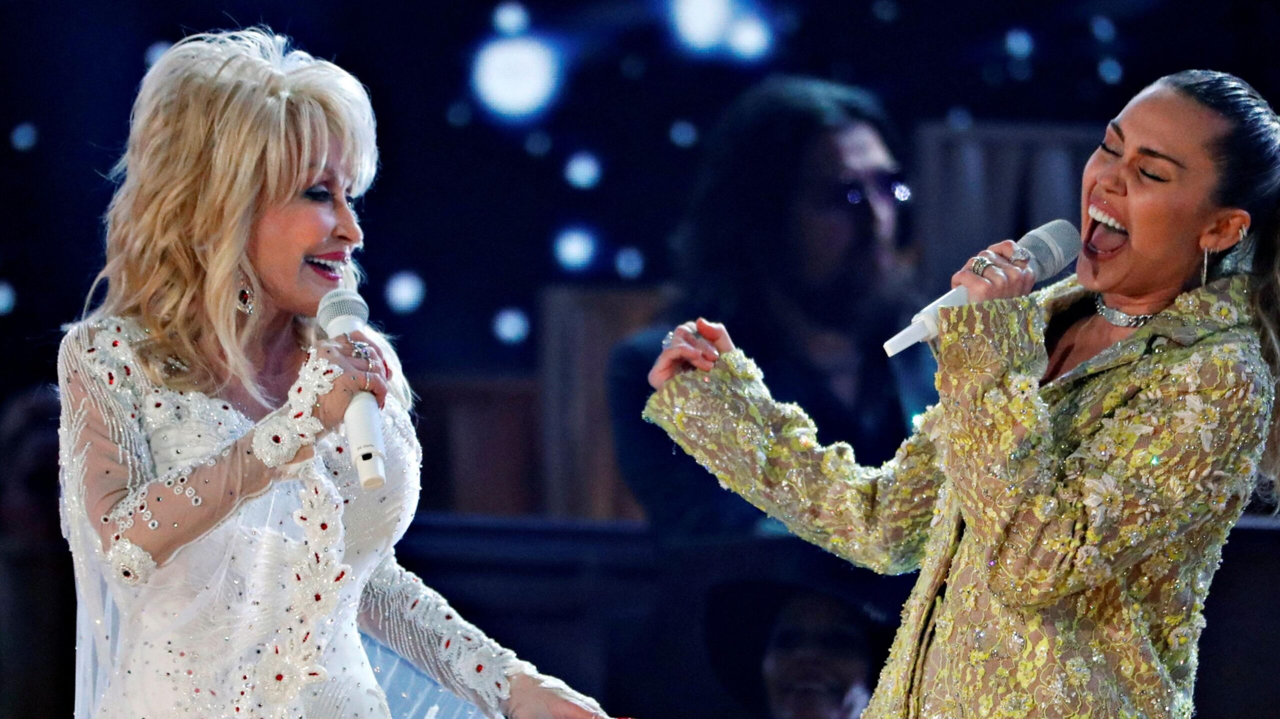 Dolly Parton singing with goddaughter Miley Cyrus (right)