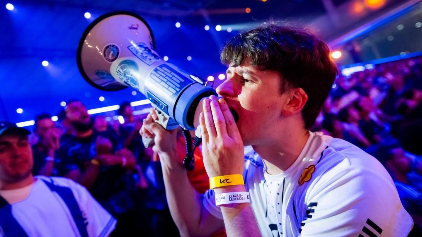 A fan at the Esports World Cup shouts into a megaphone, attempting to drum up support for his team.