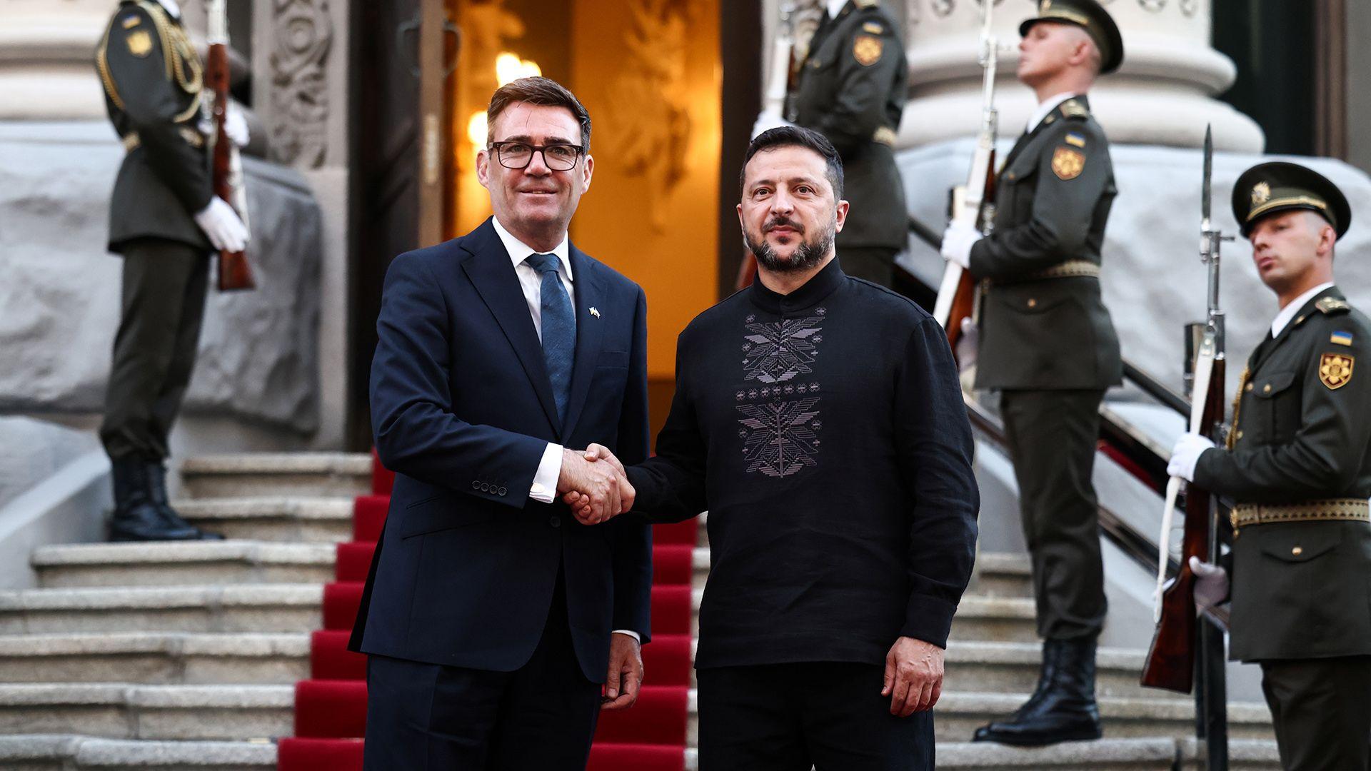 Burnham and Zelensky pose looking at the camera while shaking hands with soldiers behind them, on the steps of Horodetskyi House in Kyiv on Monday.