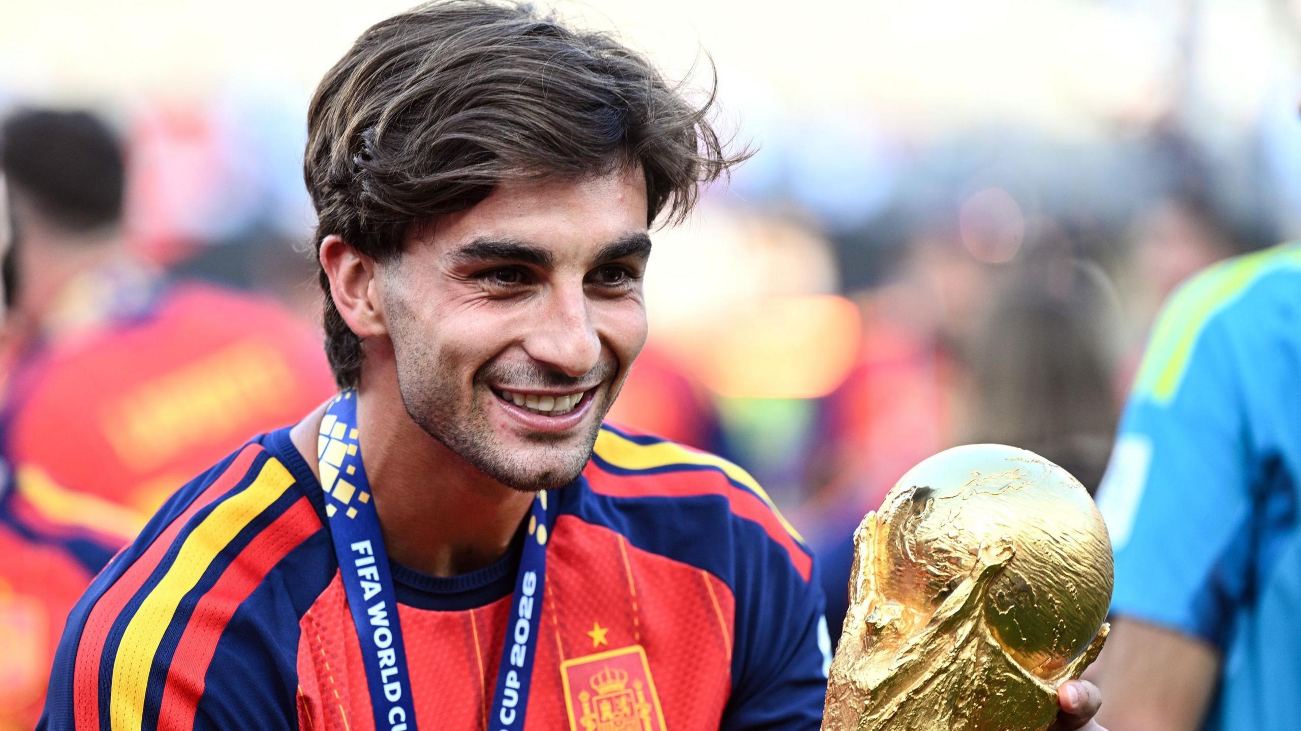 Spain forward Ferran Torres holding the World Cup trophy