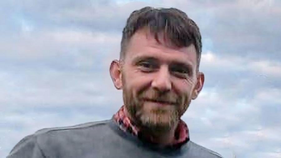 Jim Mair - a man with dark hair and a beard, smiling into the camera