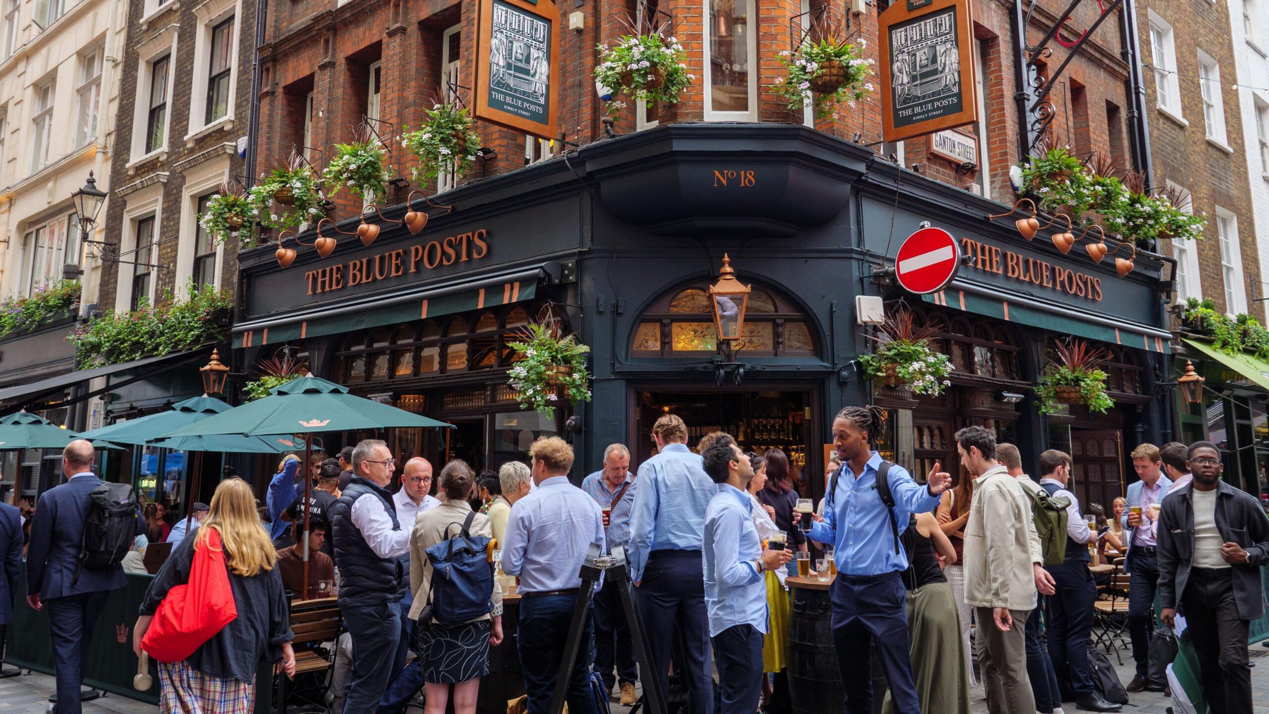 People standing and drinking outside The Blue Posts pub