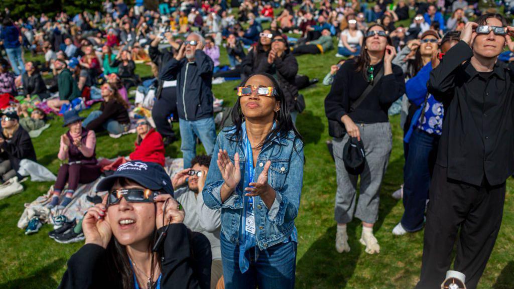 People gather at Greenwood Cemetery in Brooklyn to witness a partial solar eclipse in April 2024.